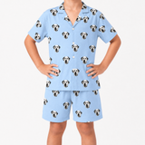 Child wearing a sky blue pajama set with dalmatian dog pattern on a white background