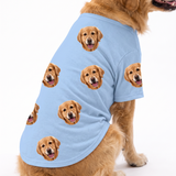 Dog wearing a sky blue custom dog shirt with a repeating dog face pattern on a white studio background.