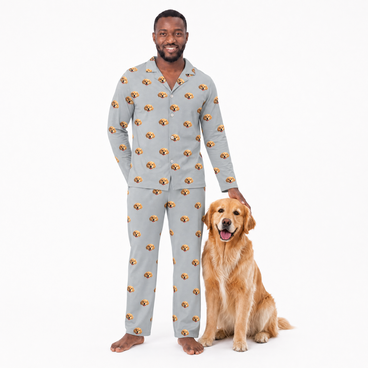 Man wearing a gray pajama set with a dog pattern, standing next to a golden retriever on a white background.