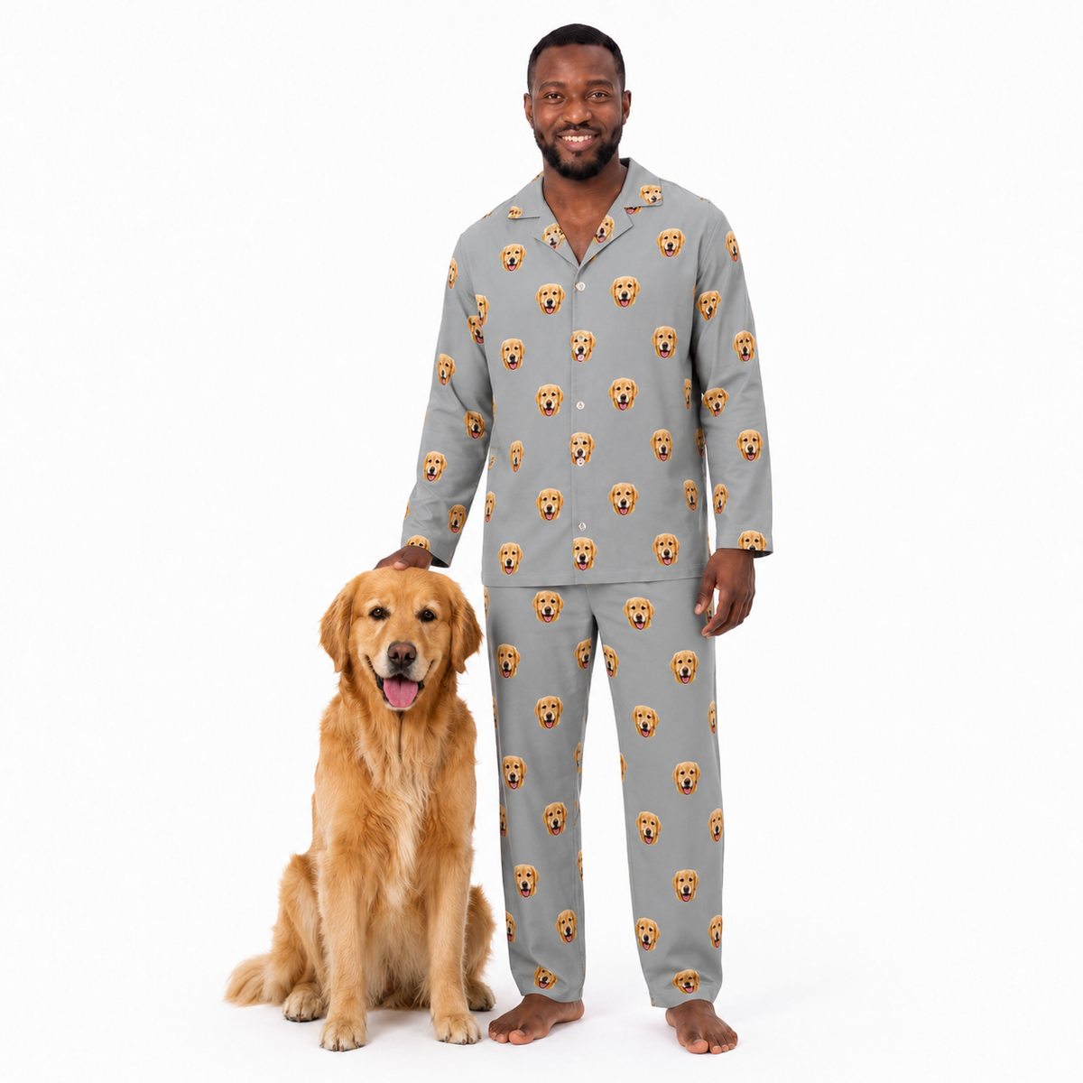 Man wearing a gray pajama set with dog faces, standing next to a golden retriever on a white background.