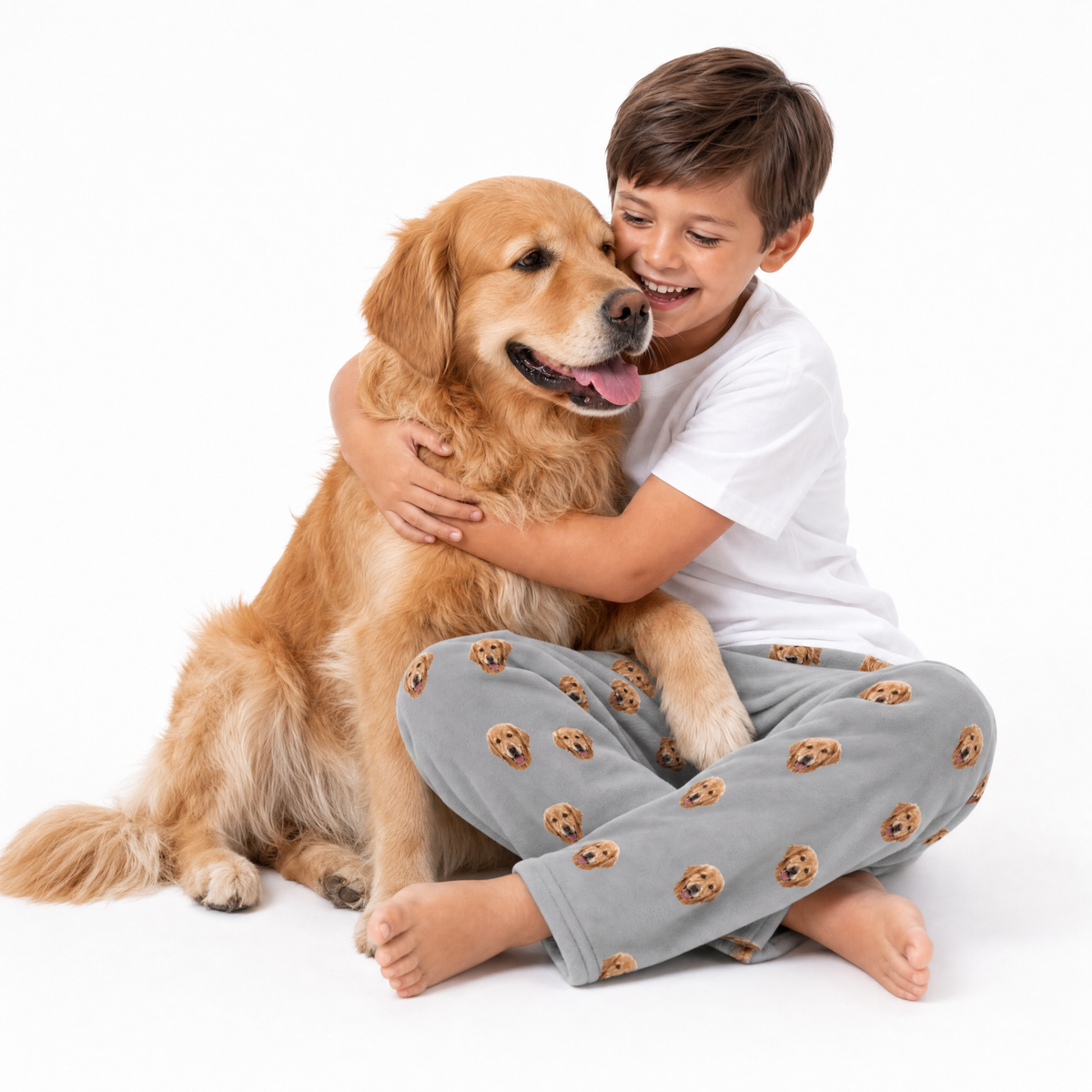 Child hugging a golden retriever dog on a white background