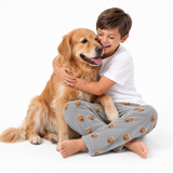 Golden retriever theme – child in slate gray dog-print pajamas hugging golden retriever.