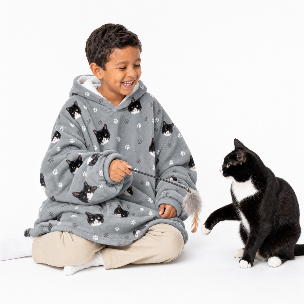 Slate gray kids fleece blanket hoodie theme – child in cat-print hoodie playing with black-and-white cat.