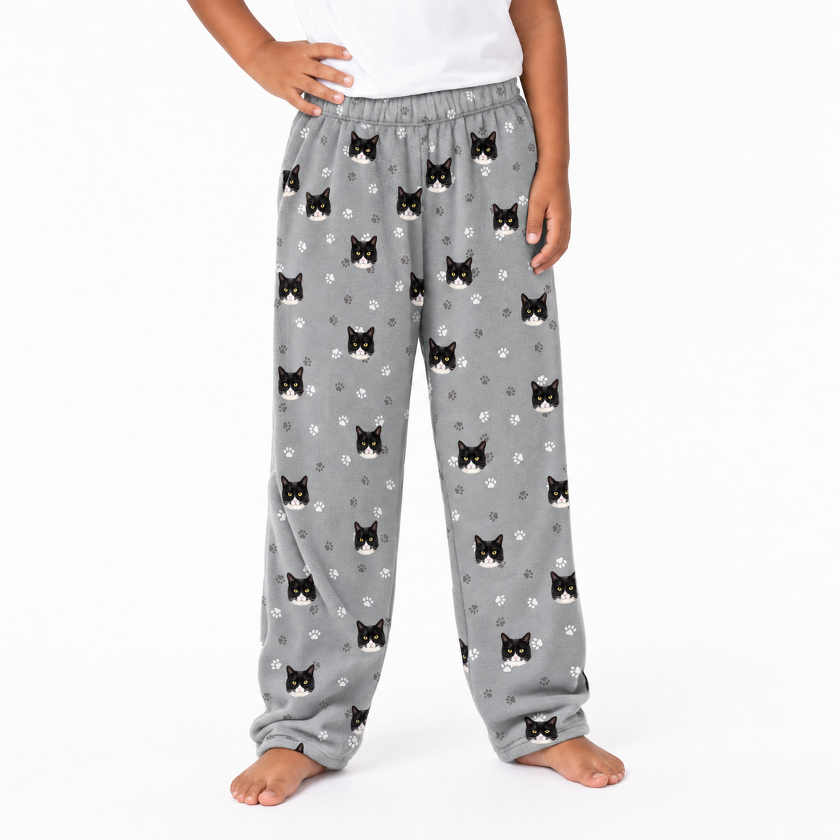 Gray pajama pants with black cat pattern worn by a person on a white background