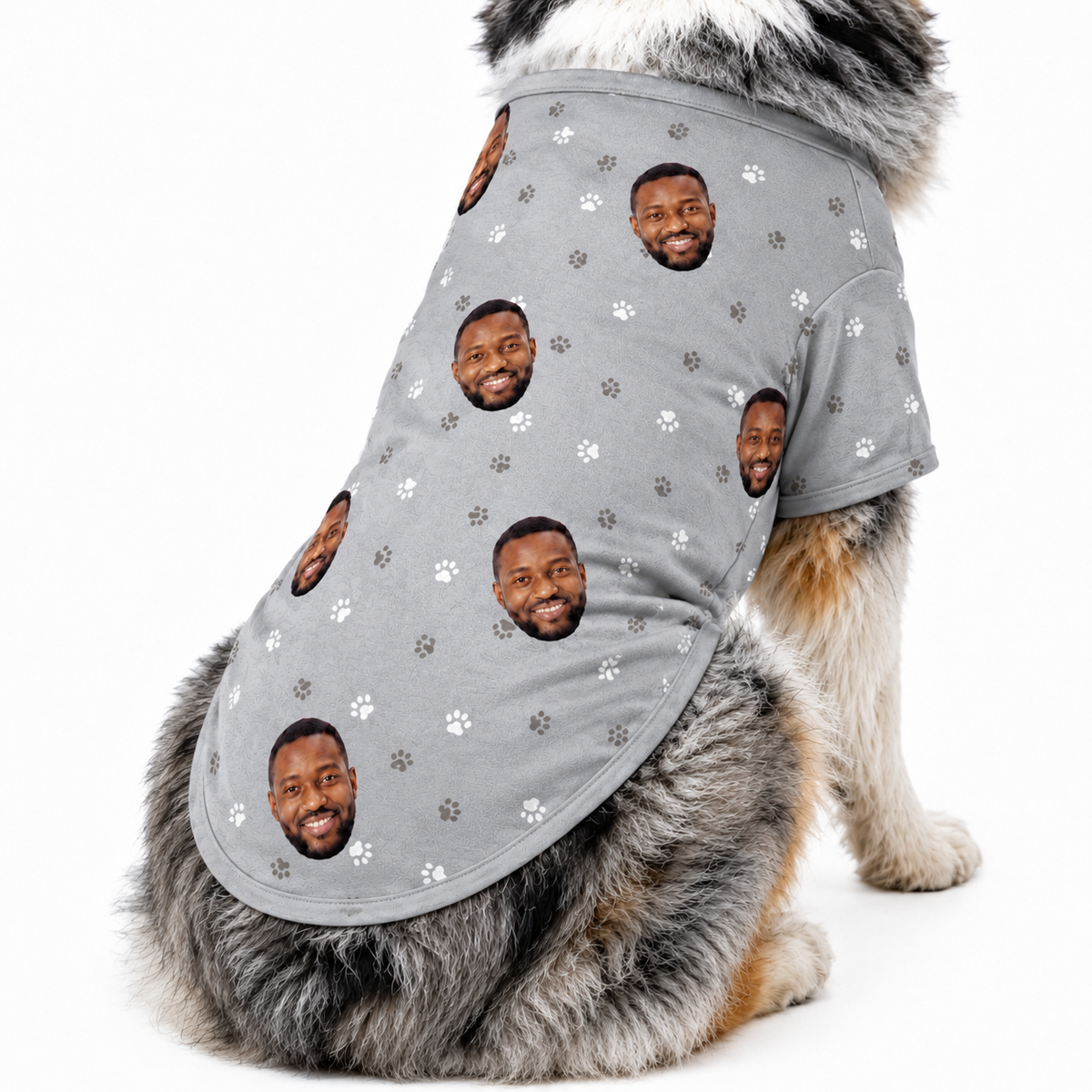 Dog wearing a gray custom dog shirt with paw prints and a repeating face pattern.