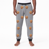 Person wearing gray sweatpants with dog face pattern on a white background