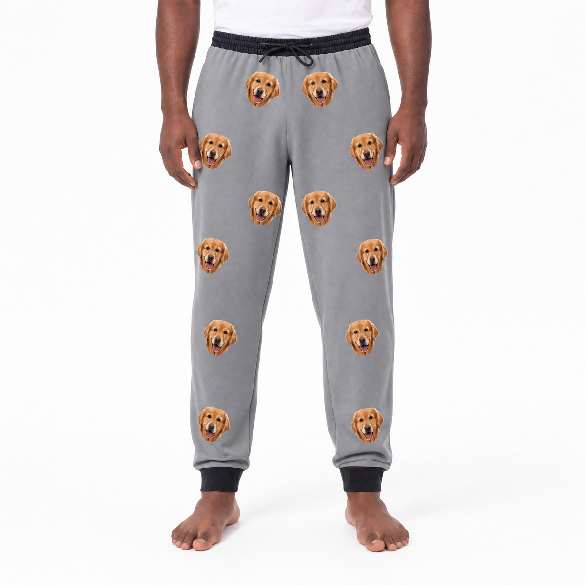 Person wearing gray sweatpants with dog face pattern on a white background