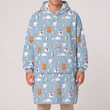 A person wearing a light blue hooded sweatshirt with an all-over winter print of polar bears, snowman, pine trees, and snowflakes, shown against a plain light gray studio background.