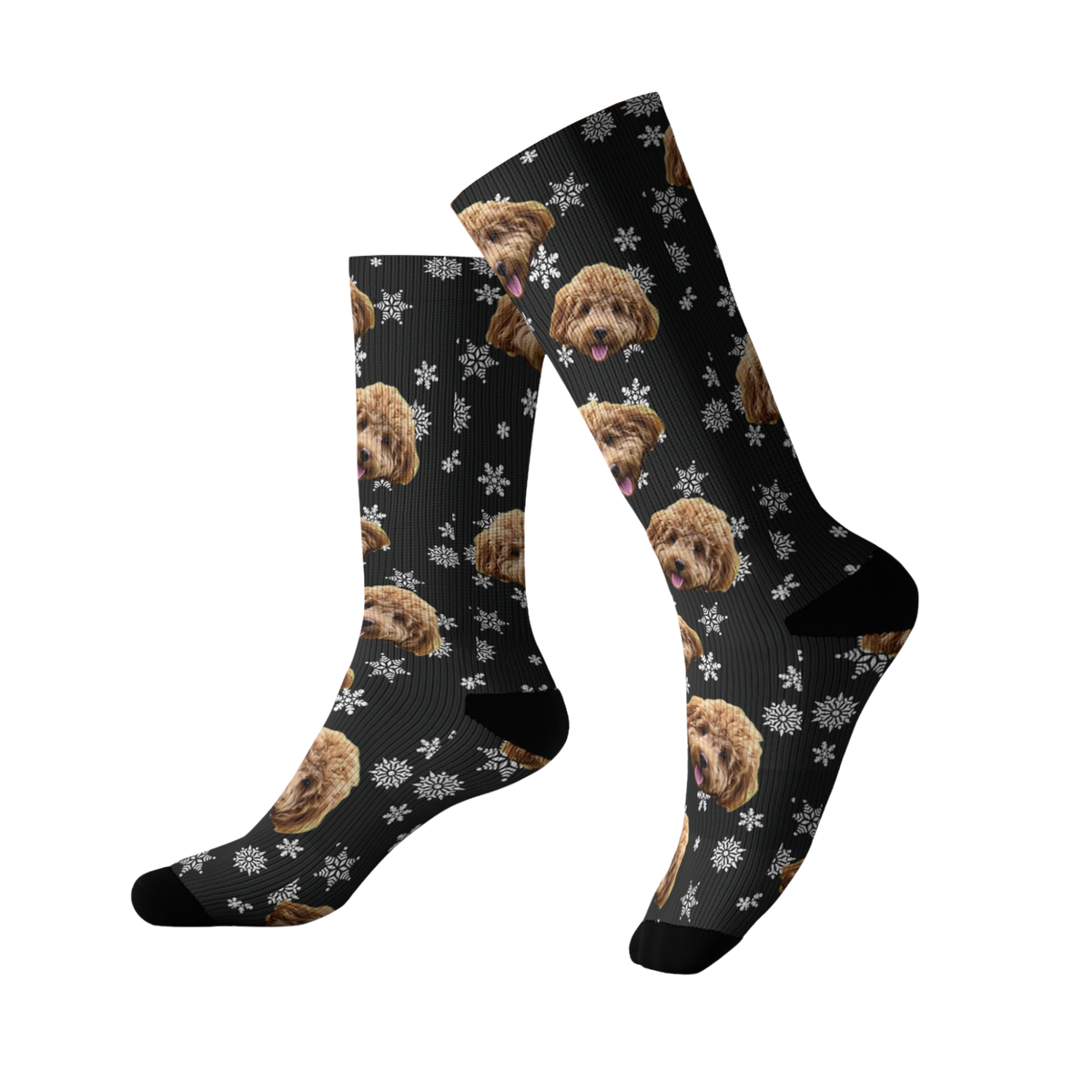 Black socks decorated with white snowflakes and a repeating pattern of a fluffy brown dog’s face. The socks have black toes and heels.