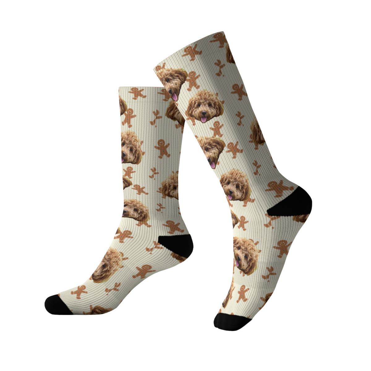 Cream-colored socks featuring a repeating pattern of a fluffy brown dog’s face along with gingerbread men and small festive accents. The socks have black toes and heels.