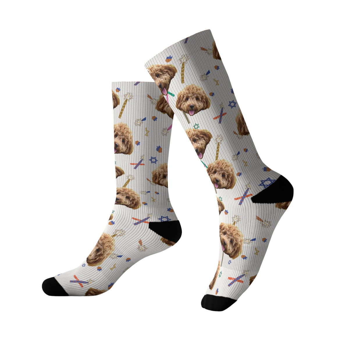White socks featuring a repeating pattern of a fluffy brown dog’s face along with Hanukkah-themed elements, Stars of David, candles, and confetti-like shapes.