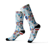 A pair of crew socks with a colorful cartoon penguin pattern on a white ribbed background, featuring black toe and heel caps, shown against a plain white background.