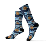 A pair of crew socks with a repeating 'Frozen Planet Snowman' cartoon pattern on a navy blue background, shown against a plain white studio background.