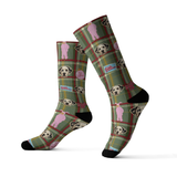A pair of green plaid crew socks featuring custom dog portraits, pink Ralphie bunny suit figures, and A Christmas Story-inspired graphics on a white background.
