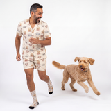 Man wearing superman pajama set with a dog on a white background