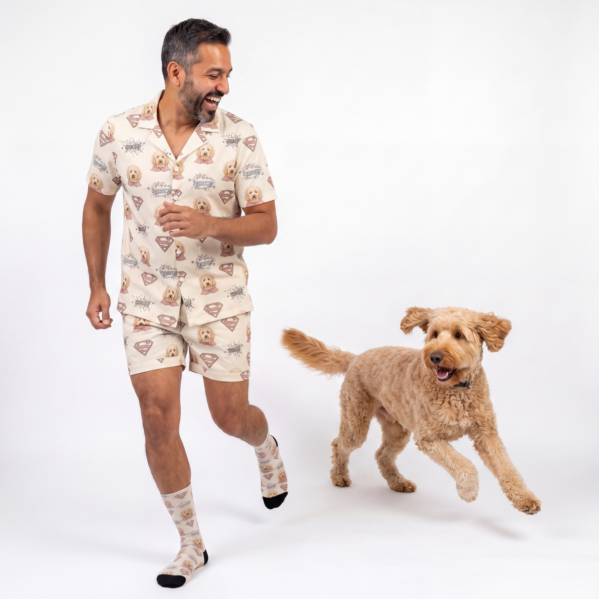 Man wearing superman pajama set with a dog on a white background
