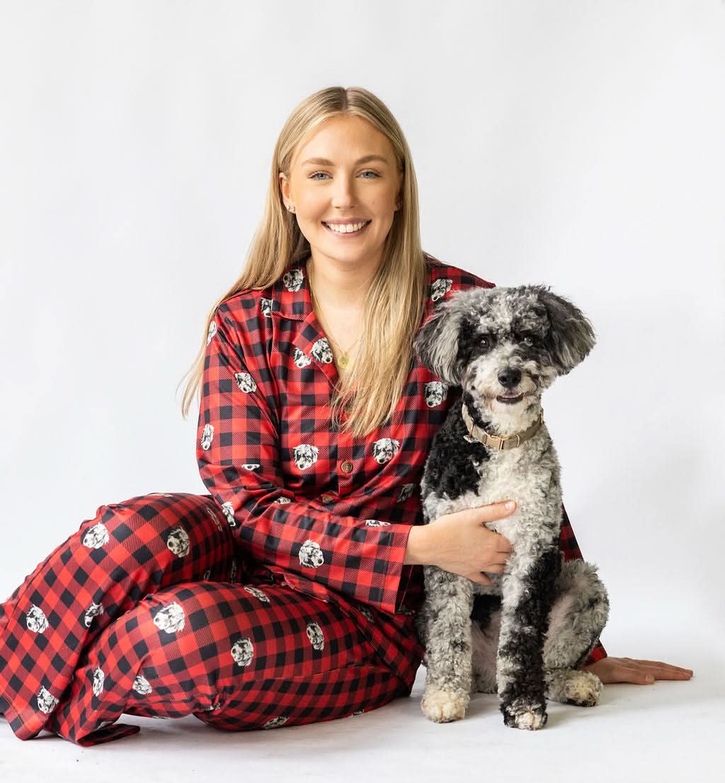 Woman in red and black checkered pajamas with a dog on a white background