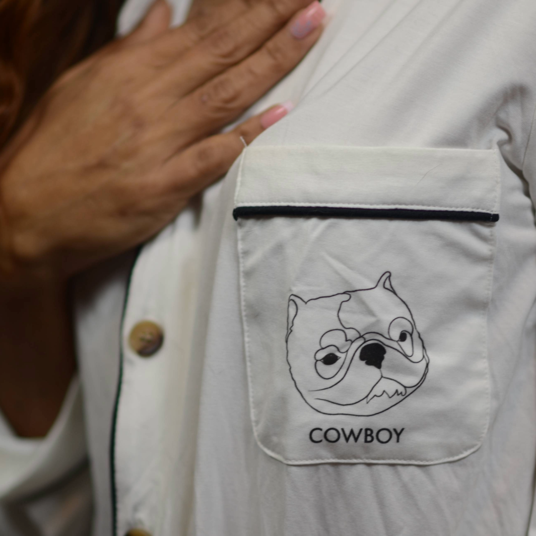 White pajama shirt with a cartoon dog face and 'COWBOY' text on a pocket.