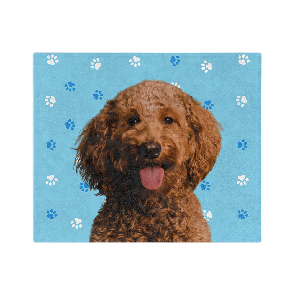 Blue blanket with paws, featuring a centered, smiling dog portrait.