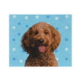 Blue blanket with paws, featuring a centered, smiling dog portrait.