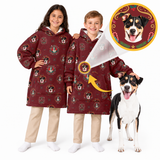 Two children wearing matching burgundy hooded sweatshirt blankets with a festive dog print, standing next to a dog, with a circular graphic showing a close-up of the dog print.
