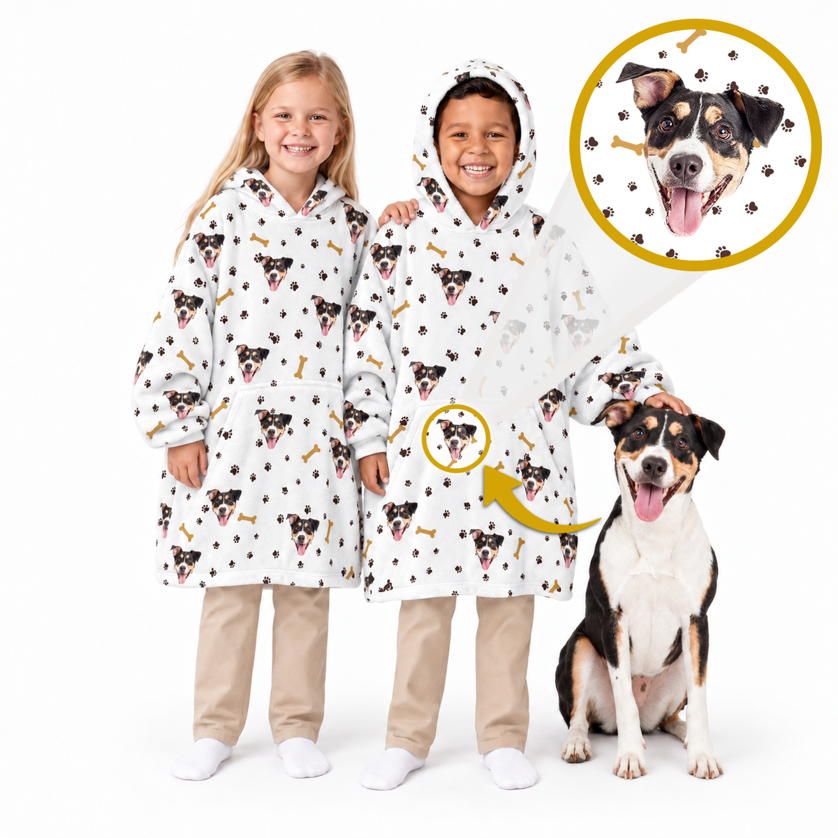 Two children wearing matching white hooded sweatshirts with a black, tan, and white dog print, standing next to a black and white dog on a white background. An inset circle shows a close-up of the dog print on the hoodie.