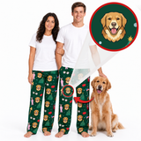 A man and a woman wearing matching white t-shirts and green Christmas-themed pajama pants with a golden retriever dog print, standing next to a real golden retriever dog. An inset circle shows a close-up of the printed dog face on the pants.