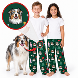 Two children wearing matching green Christmas-themed pajama pants with dog prints, standing barefoot next to an Australian Shepherd dog on a white background. An inset circle shows a custom dog portrait illustration with a red border.