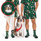 A person and a dog wearing matching green Christmas-themed pajama sets and socks with a custom illustrated dog print. The image includes a circular inset showing the original reference dog portrait and a red arrow pointing to the printed sock on the dog, illustrating the custom pet print service.
