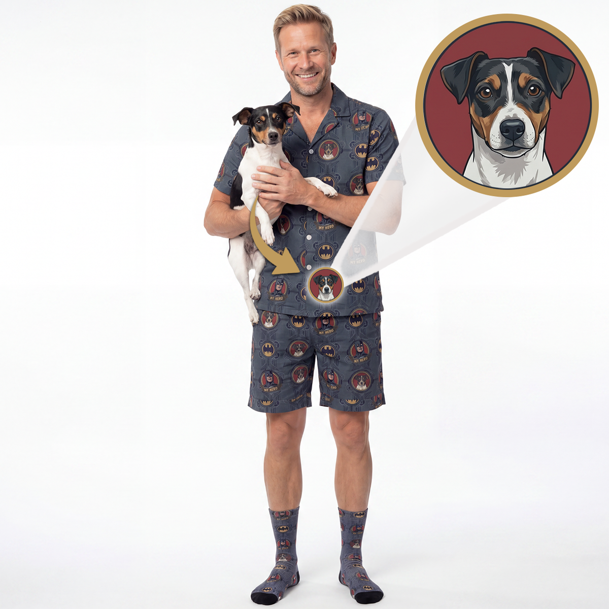 A man wearing a matching dog-themed pajama set holds a small black-and-white dog against a white studio background. The pajama shirt and shorts have an all-over dog portrait print, and a circular inset at the top right shows a close-up of one of the dog portraits.