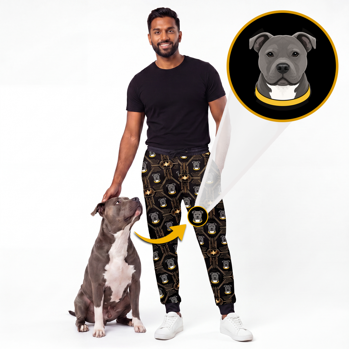 A man wearing black patterned jogger pants with a dog sitting beside him, on a white studio background. An inset circle shows a gray pitbull-style dog wearing a black and gold collar, with arrows pointing from the inset to the pants pattern, indicating the product is custom pet name prints.