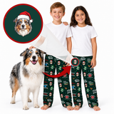 Two children and a dog wearing matching Christmas pajamas, with a circular inset showing a dog portrait printed on the pajama leg. The pajama set is dark green with a festive Santa Claus and holiday print.