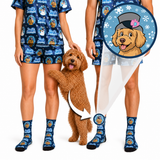 A person wearing a matching blue dog-themed pajama set and socks stands beside a brown poodle dog, with a circular inset showing a close-up of the dog printed on the sock. The scene is a clean studio composite on a white background.