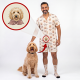 A man wearing a matching beige short-sleeve pajama set with a dog print stands next to a golden doodoodle dog on a white studio background. An inset circle shows a cartoon illustration of the dog wearing a pink bow tie, with arrows pointing to the man's pajama print and the dog's collar area.