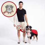 A man and a dog stand against a white studio background wearing matching printed socks and shorts. A circular inset at the top left shows a dog portrait with a red bandana, and the man's shorts are highlighted with a red circle and arrow pointing to the matching sock-and-shorts print on his leg.