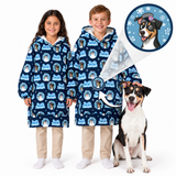Two children wearing matching navy blue hooded blankets with a repeating dog-themed print, standing next to a dog on a white background. A circular inset shows the printed design in detail.