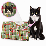 Custom Christmas wrapping paper featuring a black and white cat portrait printed on a festive green plaid design beside the real cat