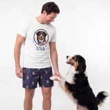 Man wearing a white t-shirt with a dog graphic and 'USA' text, standing next to a dog on a white background
