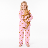Child wearing pink pajamas with cat pattern holding a cat on a white background