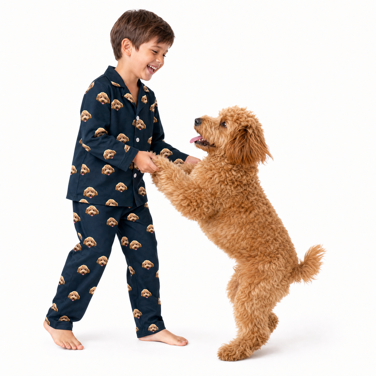 Child wearing black pajamas with dog pattern interacting with a dog on a white background