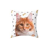 White pillow with paws and bones, it features a portrait of a cat.