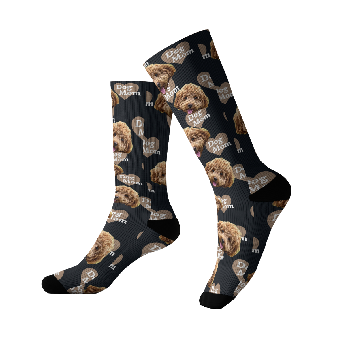 Black socks featuring a repeating pattern of a fluffy brown dog’s face along with the phrase “Dog Mom” printed in white across the design. The socks have black toes and heels.