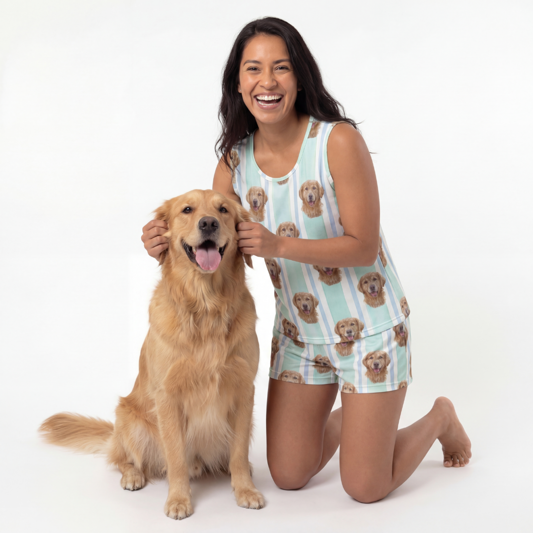 Woman wearing tank top pajamas set kneeling next to a golden dog on a white background