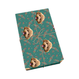 Teal pet wrapping paper with dog portraits, holly berries, and a golden ribbon design.