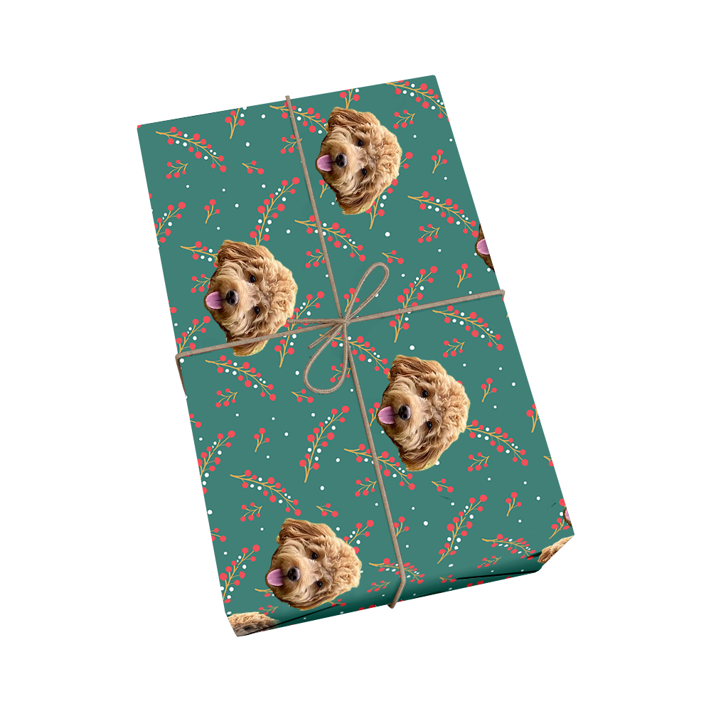 Custom pet wrapping paper in teal featuring repeating pattern of dog portraits with red holly berries and green leaves for Christmas celebration with golden ribbon design