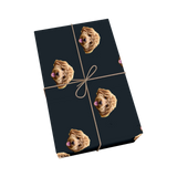 Black pet wrapping paper with dog portraits and a golden ribbon design.