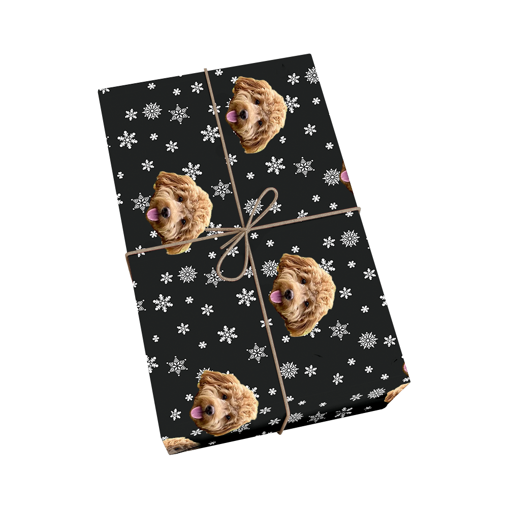 Custom pet wrapping paper in black with dog portraits and white snowflakes with golden ribbon accent