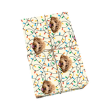 Custom pet wrapping paper in cream color with dog portraits and colorful string Christmas lights.