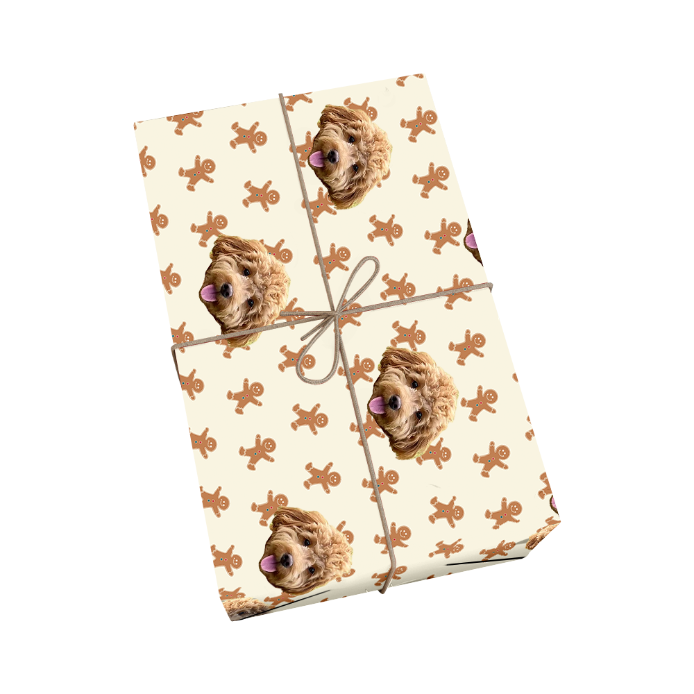 Custom pet wrapping paper in cream color featuring dog portraits and gingerbread man shapes with golden ribbon accent