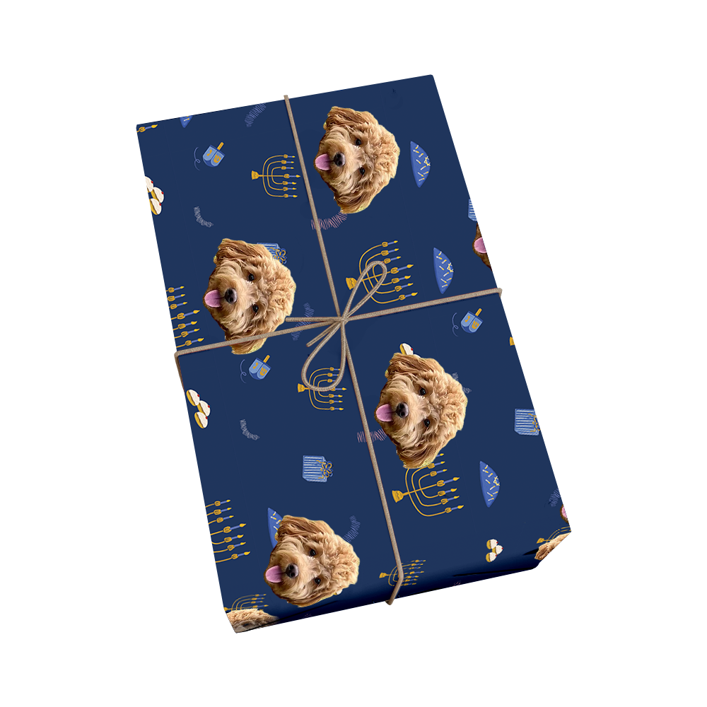 Custom pet wrapping paper in dark blue featuring repeating pattern of dog portraits with golden menorahs and dreidels for Hanukkah celebration with golden ribbon design